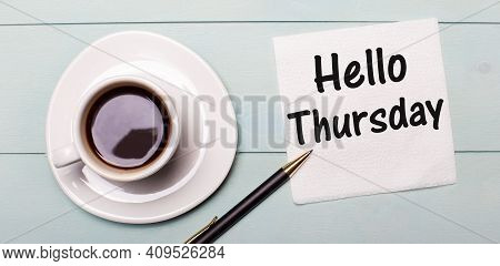 On A Light Blue Wooden Tray, There Is A White Cup Of Coffee, A Handle And A Napkin That Says Hello T