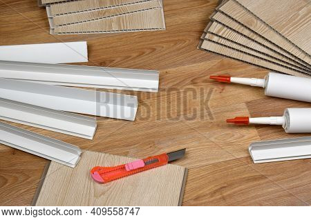 Set Of Items For Pvc Ceiling Indoor Works. Assembly Adhesive Bottles And Pvc Panels With Plastic Cor
