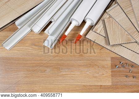 Set Of Items For Pvc Ceiling Indoor Works. Assembly Adhesive Bottles And Pvc Panels With Plastic Cor
