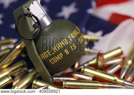 M67 Frag Grenade And Many Yellow Bullets And Cartridges On United States Flag. Concept Of Gun Traffi