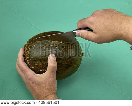 Man Cutting A Melon With A Knife