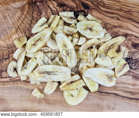 Some Dried Banana Chips On Olive Wood