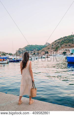 Young Beautiful Woman Walking On Dock Near The Boat