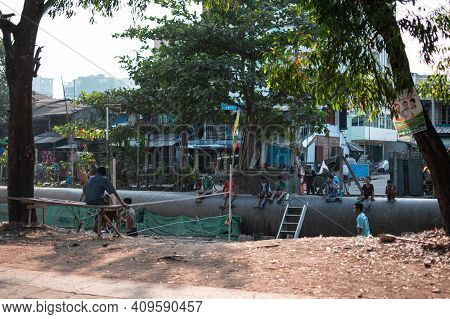 Yangon, Myanmar - Decemeber 31 2019: Local People Play Traditional Chinlone Ball With Spectators Sit