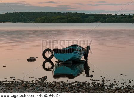 Boat On The Lake With Reflection In The Water At Sunset. Lough Owell Lake.