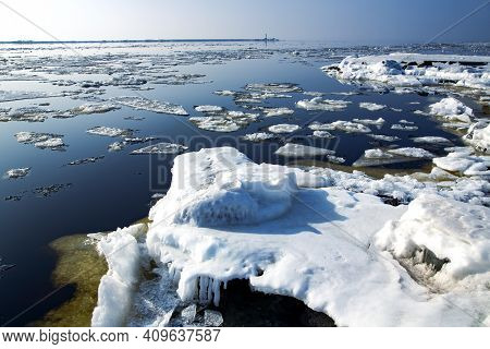 Icy Road To The Lighthouse On Mangalsala Pier In Baltic Sea Located At Riga Sea Port, Latvia, Europe