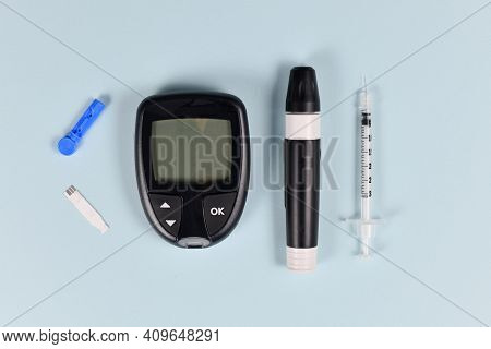Diabetes Treatment Equipment With Blood Glucose Sugar Meter, Lancet, Syringe And Lancing Device On B