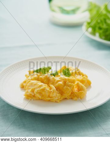 Scrambled Eggs, Omelette. Breakfast With Pan-fried Eggs. Texture Of Omelet On White Plate On Green M