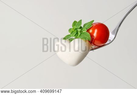 Mozzarella Heart With Tomato And Green Basil On A Fork. Mozzarella Cheese In Heart Shape On A White 