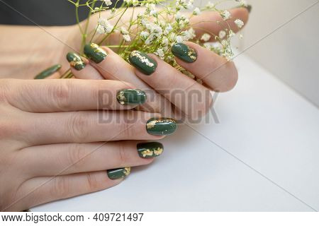 Hands With Beautiful Hakki Manicure And Gold Foil. A Woman Is Holding A Branch With White Flowers. B
