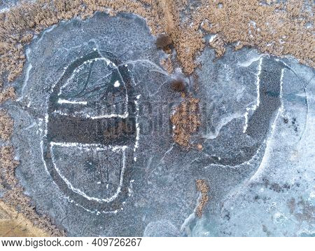 Melting Ice On Frozen  Lake Aerial Drone Shot With Dried Vegetation At Early Spring.