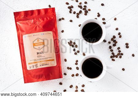 Tiraspol, Moldova - February 12, 2021: Red Coffee Bag With Degassing Valve, Two Cups Of Brewed Coffe