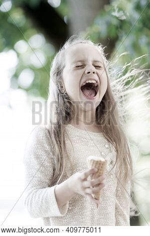 Ice Cream Makes Her Fall Into Euphoria. Cute Little Girl Eating Ice Cream On Summer Day. Small Child