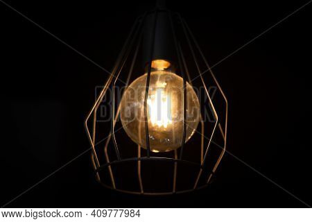 Vintage Edisson Lamp With Black Forged Wire Lampshade, On Dark Background