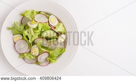 Cucumbers, Quaill Eggs,  Radish And Lettuce On A Plate. Fresh Vegetables Salad Isolated On White Bac