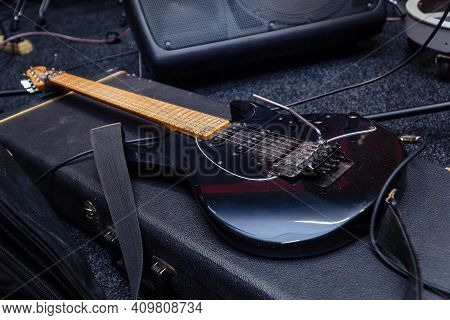 Black Electric Guitar With Tremolo On A Hard Case. Selective Focus