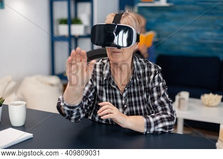 Happy Senior Woman Wearing Virtual Reality Headset Doing Hand Gesture. Cheerful Elderly Woman Experi