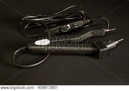 Hair Extension Tongs On A Black Background. High Quality Photo