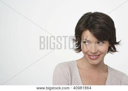 Happy beautiful woman glancing sideways isolated over white background