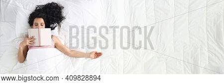 Woman Lies On White Bed With Closed Eyes Book Lies On Her Face. Relax And Tranquility Before Bed Con