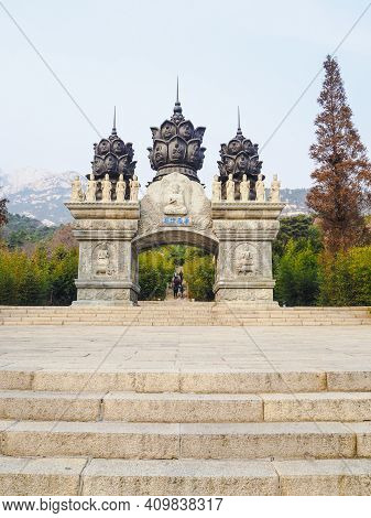 Qingdao, China - December 2017: White Carved Buddhist Archway 'huazang Shijie' As The Entrance To Th