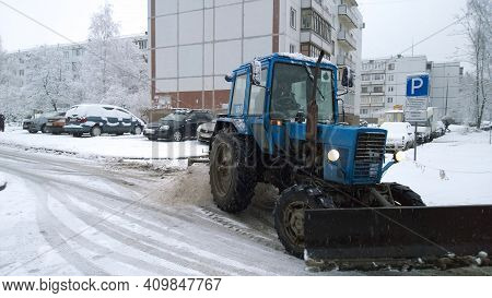 Pskov, Russia - December, 2020: Winter Is Here. Snowfall In The City. Tractor Remove Snow And Ice On
