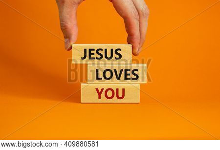 Jesus Loves You Symbol. Concept Words 'jesus Loves You' On Wooden Blocks On A Beautiful Orange Backg
