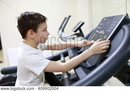Boy Exercising At Stride Treadmill