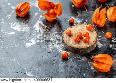 Physalis On Wooden Stump. Ripe Berries Of Autumn Red Physalis Fruit. Berries Fruit. Physalis Or Chin