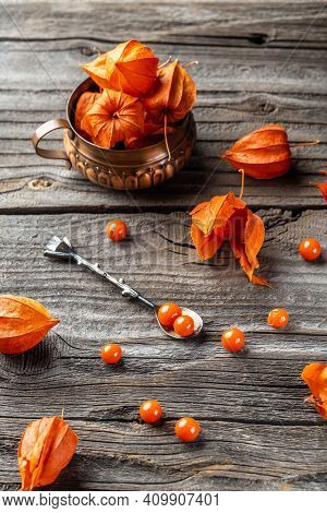 Physalis On Wooden Stump. Ripe Berries Of Autumn Red Physalis Fruit. Berries Fruit. Physalis Or Chin