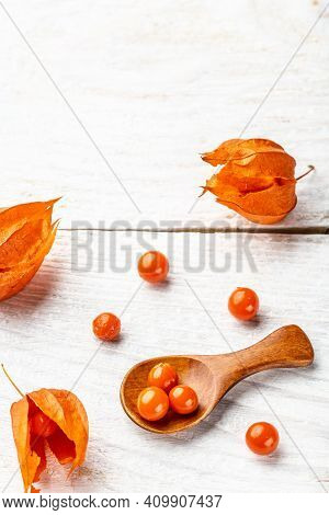 Physalis On Wooden Stump. Ripe Berries Of Autumn Red Physalis Fruit. Berries Fruit. Physalis Or Chin