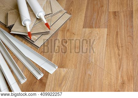 Set Of Items For Pvc Ceiling Indoor Works. Assembly Adhesive Bottles And Pvc Panels With Plastic Cor