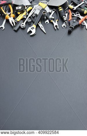 Handyman Tool Kit On Black Wooden Table. Many Wrenches And Screwdrivers, Pilers And Other Tools For 