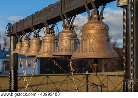 A Row Of Orthodox Bronze Bells Hang On A Metal Beam