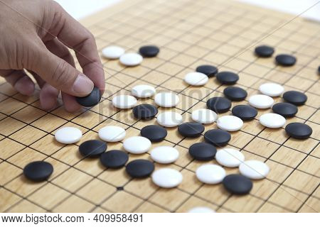 Player\'s Hand Put Stone On The Game Board - An Ancient Game Also Known As Baduk In Korean, Weiqi In
