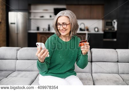 Well-dressed Gray Haired Woman On Retirement Managing Family Budget At Home, Smile And Paying The Bi