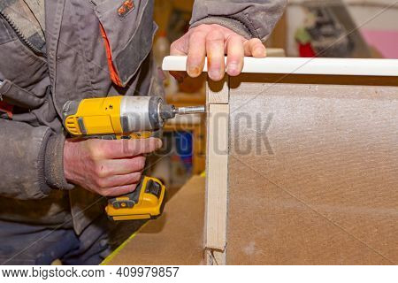Worker In Carpentry Uses Professional Manual Power Tool, Acu Drill, And Twists The Screws On The Woo
