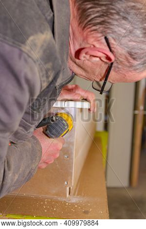 Worker In Carpentry Uses Professional Manual Power Tool, Acu Drill, And Twists The Screws On The Woo