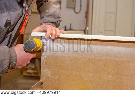 Worker In Carpentry Uses Professional Manual Power Tool, Acu Drill, And Twists The Screws On The Woo