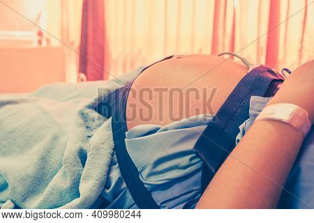 Closeup Of Pregnant Woman With Electrocardiograph Check Up For Her Baby In The Hospital. Fetal Heart