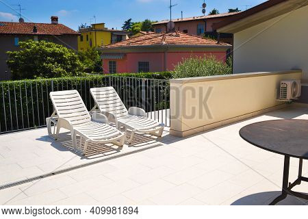 Empty Sun Beds Deck Chairs And Table On Sun Lounger In Apartment Or Hotel. Relaxing Summer Day, Luxu
