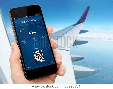 Woman Hand Holding The Phone With Mobile Wallet And Plane Ticket Against The Background Of The Blue