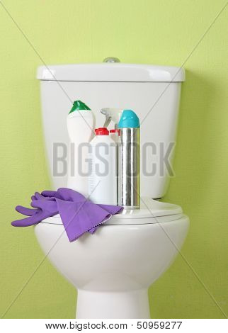 White toilet bowl and cleaner bottle in a bathroom