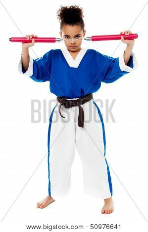 Young Girl In Karate Uniform Holding Nunchucks