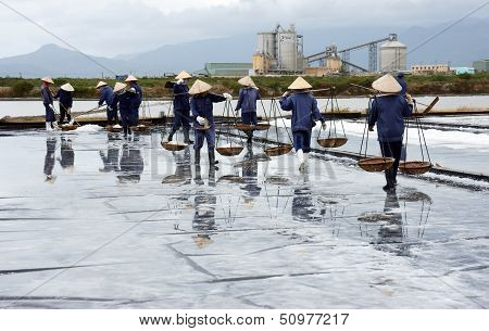 Salt worker working on salina