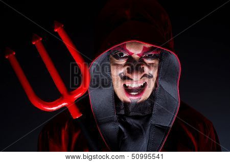 Man in devil costume in halloween concept