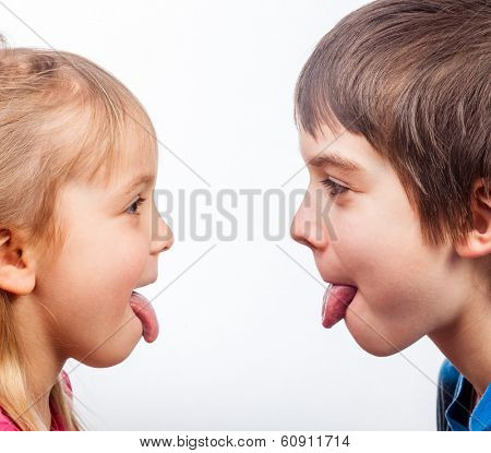 Sister and brother stick out tongues to each other