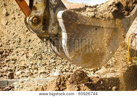 Wheel loader machine unloading sand at eathmoving works in construction site