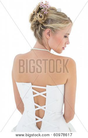 Rear view of young bride in off shoulder dress against white background