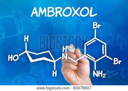 Hand with pen drawing the chemical formula of ambroxol